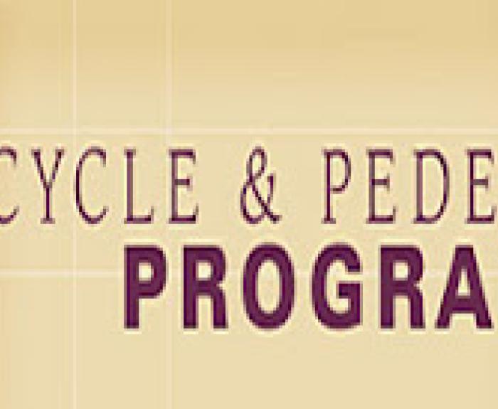 Banner with text Bicycle & Pedestrian Program and a faded image of a person riding a bicycle on the left.