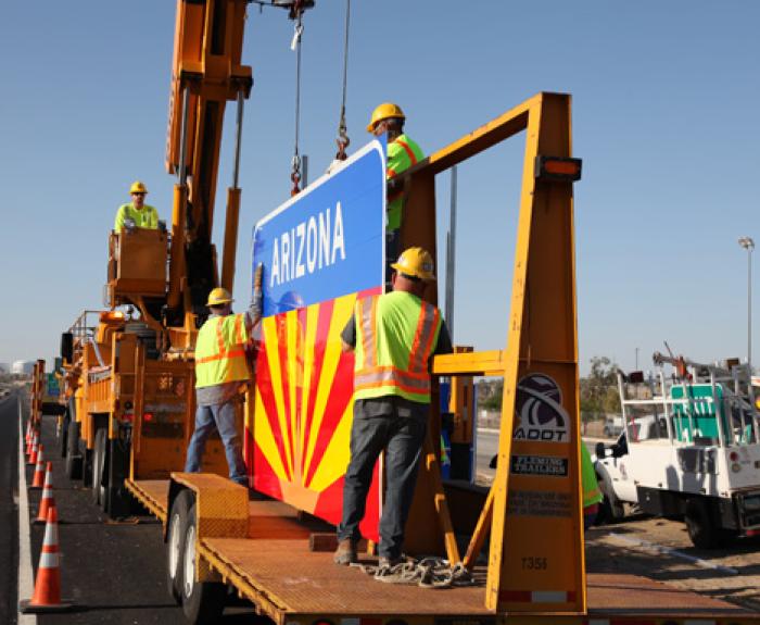 ADOT workers remove sign from trailer along highway