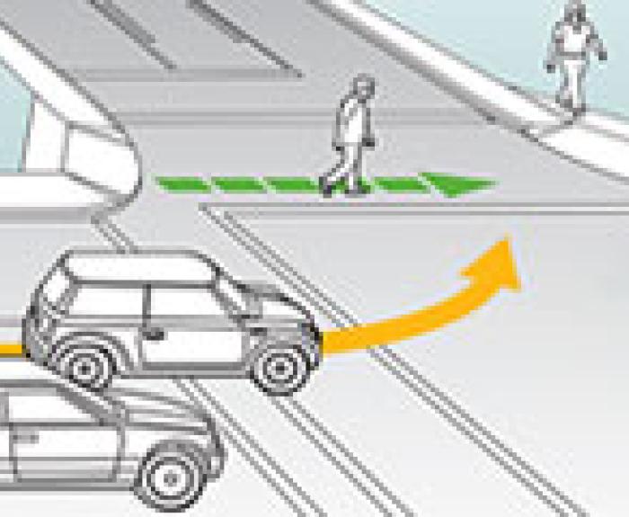 Car turning left and a pedestrian in crosswalk