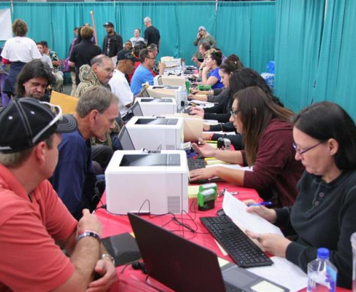 Motor Vehicle Division workers at table helping veterans