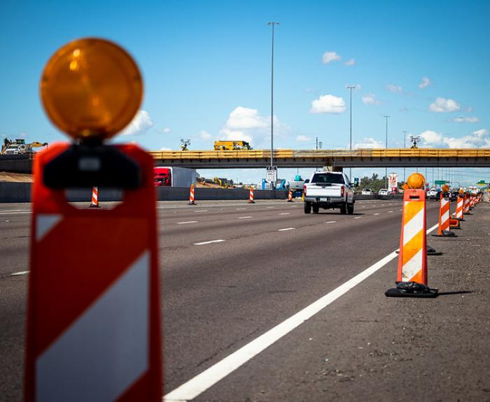 Traffic in freeway work zone marked by barricades