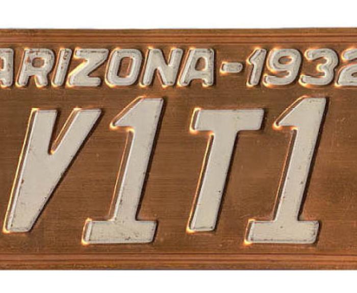 Arizona 1932 license plate with the number V1T1 in white letters on a copper background.