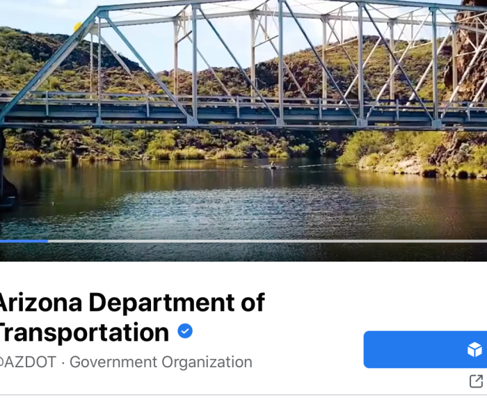 A steel bridge spans a river with hills in the background on the Arizona Department of Transportation page.