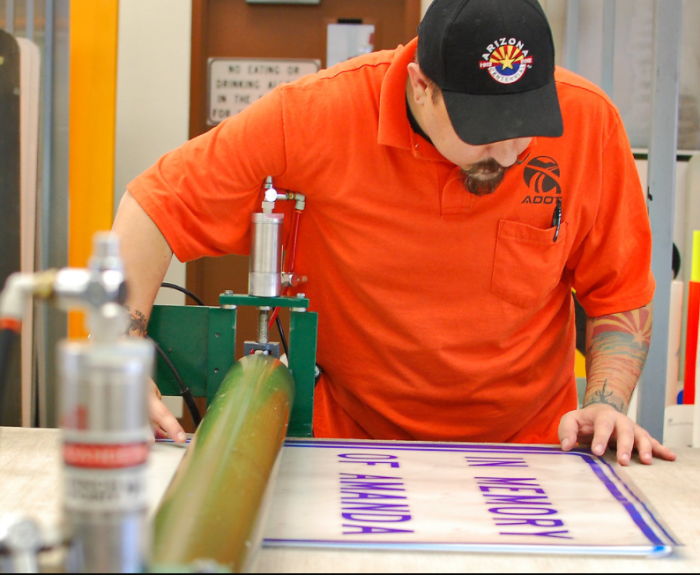 ADOT technician making a road sign.