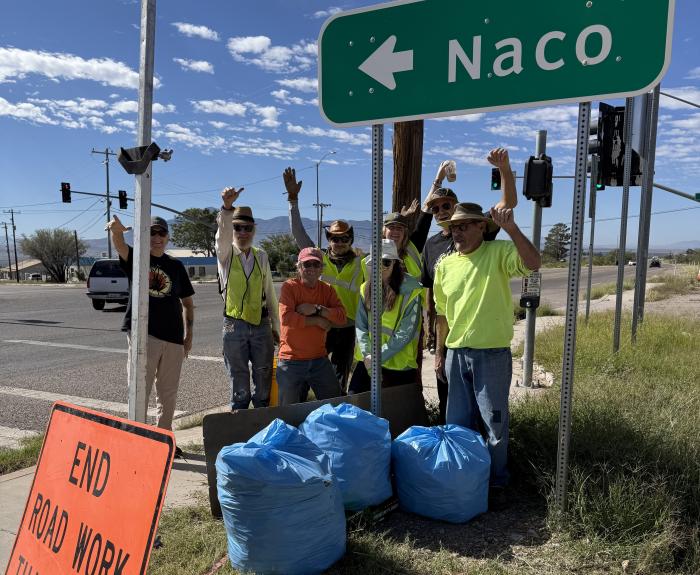 Adopt a Highway volunteers near Naco directional signage.