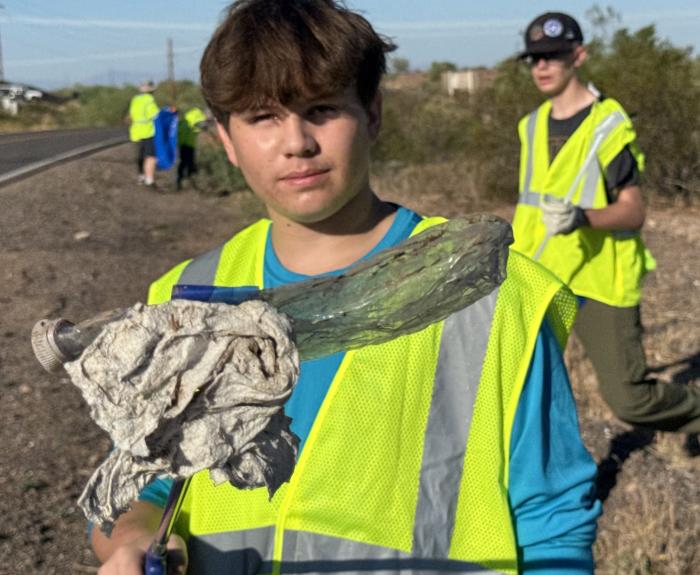 Adopt a Highway volunteer holds up a piece of litter. 