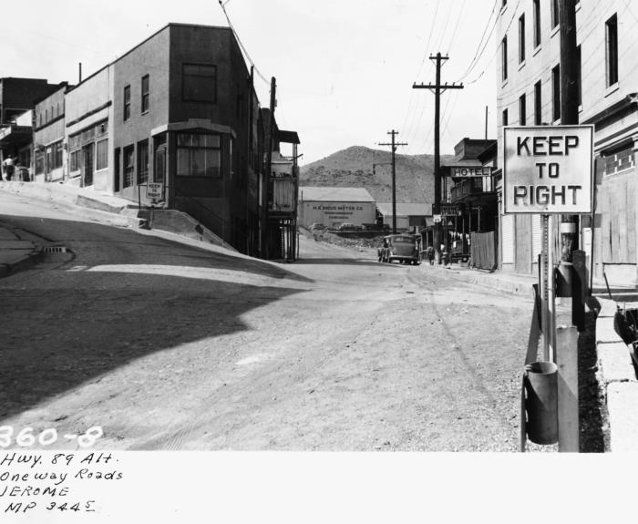 Black and white photo of a street in Jerome, Arizona, showing buildings, telephone poles, a KEEP TO RIGHT sign, and handwritten notes at the bottom.