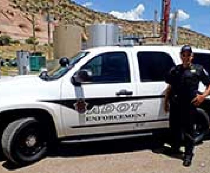 ECD officer in front of ADOT enforcement vehicle