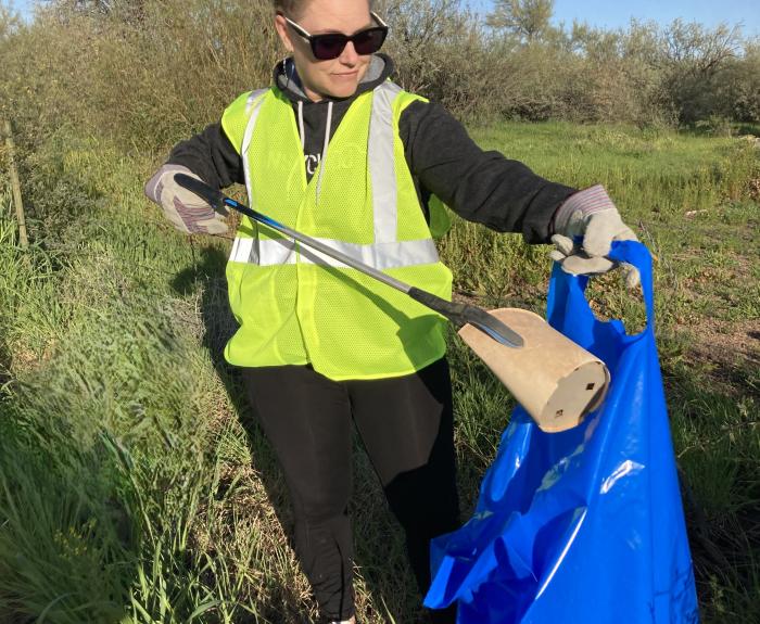 Volunteer placing trash in ADOT bag