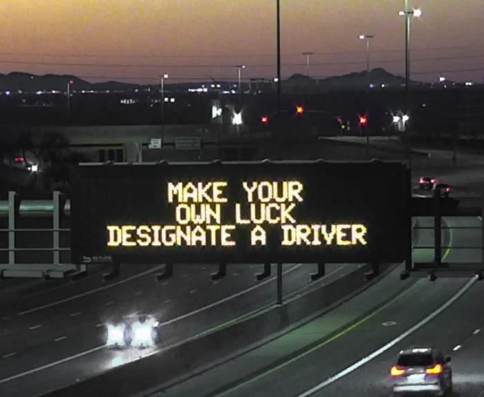 A digital message board on the highway encourages motorists to designate a driver.