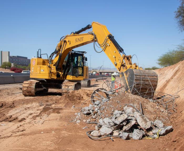 Demolition happening in a freeway work zone.