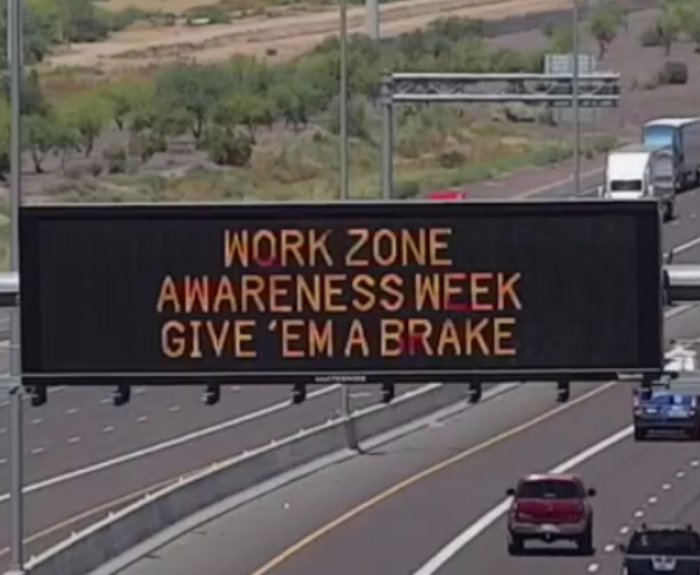 A digital message board on the highway encourages motorists to slow down in work zones.
