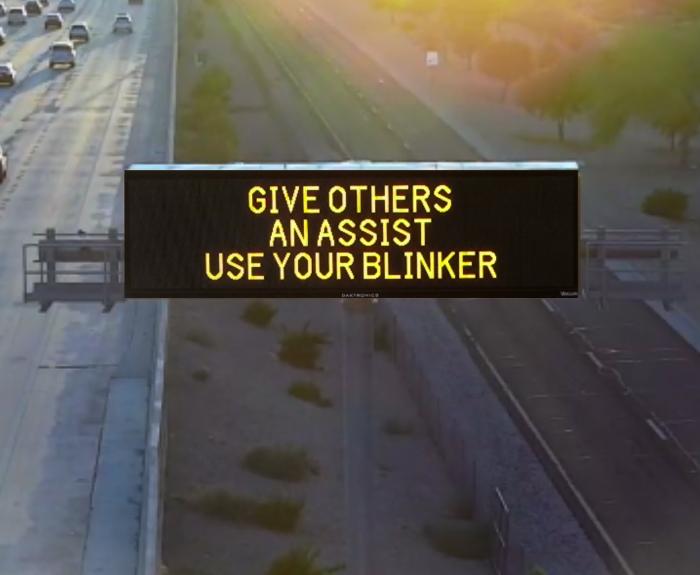 A digital message board on the highway encourages motorists to use their blinker..