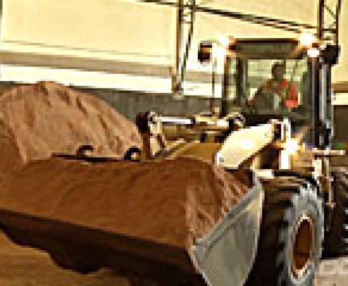 Image of a tractor scooping de-icer 