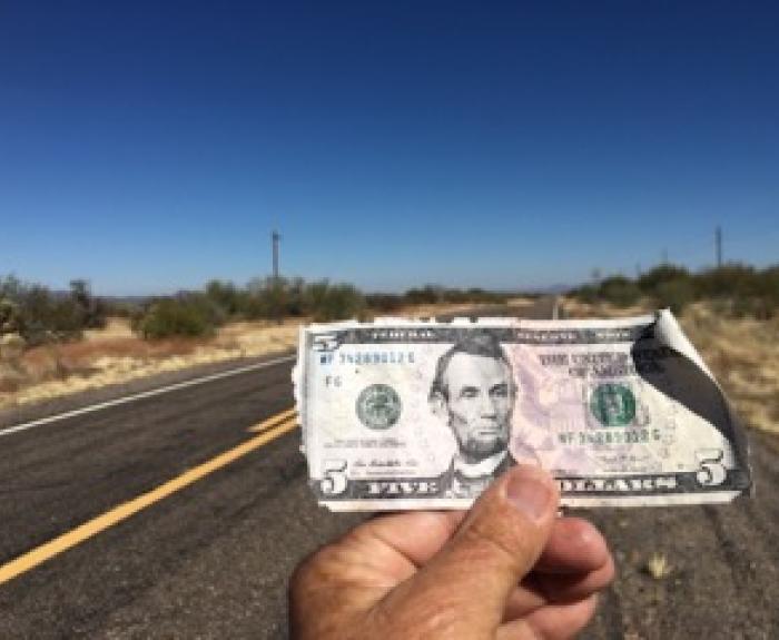 Five dollar bill in hand found during a cleanup
