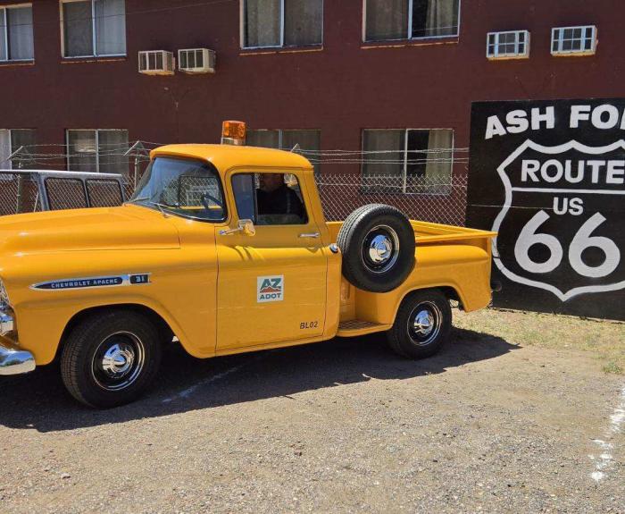 Yellow truck in front of sign that says "Ash Fork Route 66"
