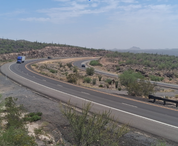 Image of fresh paved road with semi truck driving on it.