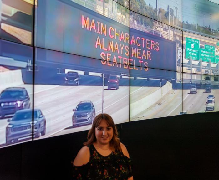 A woman standing in front of screens 