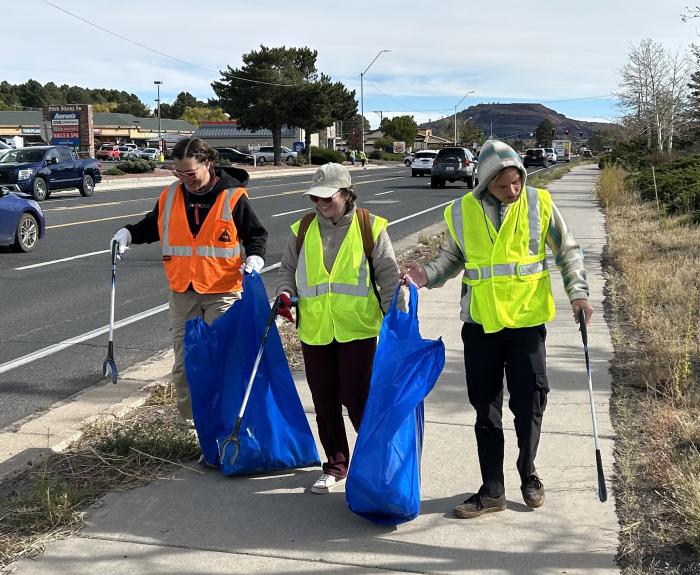 Volunteers remove litter from along a road in Flagstaff.