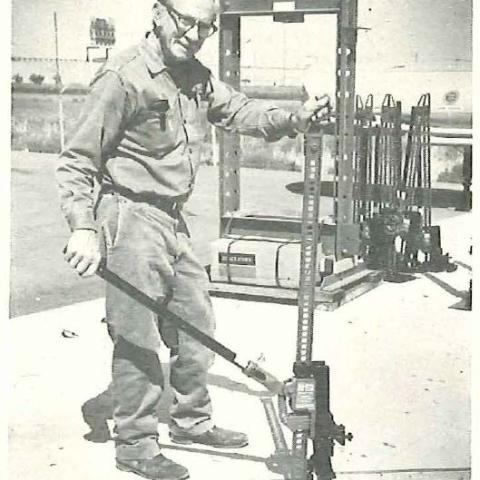 A man stands next to a construction tool.